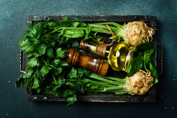 Fresh celery root and celery stalk in a wooden box. Vegetables for detox and diet. On a black stone background. Top view.
