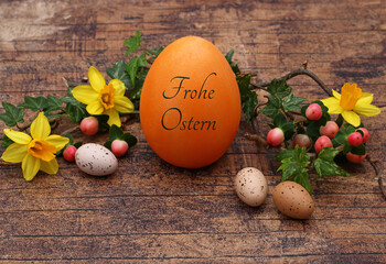 Grußkarte Frohe Ostern: Arrangement mit Blumen und einem beschriftetem Osterei.