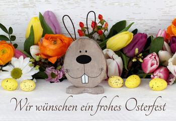 Grußkarte Frohe Ostern: Arrangement mit Osterhasen, Blumen und bunten Ostereiern.