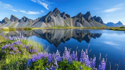 Fototapeten A stunning landscape of Iceland's Stokksnes, featuring the majestic flat-topped mountain and vibrant blue skies. The scene includes an enchanting lake reflecting distant mountains © Kien