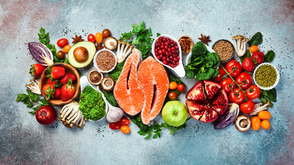 Top view. Healthy food selection on gray background. Detox and clean diet concept. Foods high in...