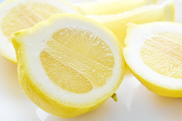 Fresh lemon on a white plate. Citrus lemon half cut close up. 
