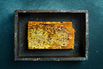 Natural honeycombs with honey. On a dark background. Top view. In a wooden box.