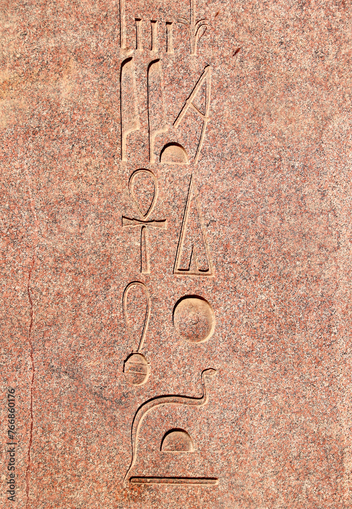 Wall mural Vertical background with ancient Egyptian hieroglyphs on red granite wall, Egypt, Africa. Backdrop with granite carving with hieroglyph. Copy space for text