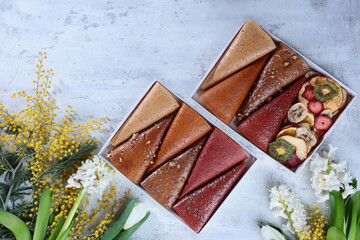 Fruit pastille. The pastille is rolled up in the form of a cone. Vegan sweets, dessert without sugar. Spring flowers. The concept of healthy eating.