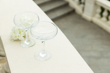 Two glass glasses with flowers on the background of the sea.