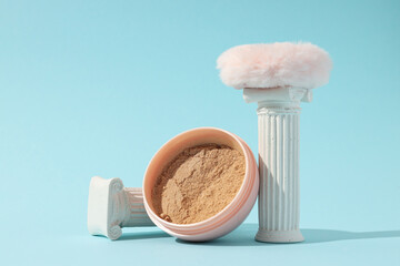A bottle of loose powder, light shade, on a blue background.