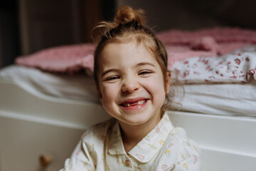 Portrait of cute girl smiling with gap-toothed grin, missing her baby teeth.