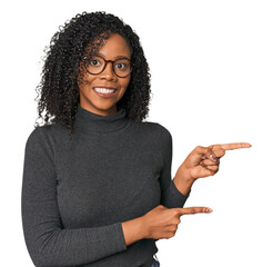 African American woman in studio setting shocked pointing with index fingers to a copy space.