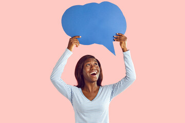 Happy excited young african american woman holding blank speech bubble for thoughts isolated on pink studio background. Girl with empty word cloud offering space for text. Idea concept. - 766866959