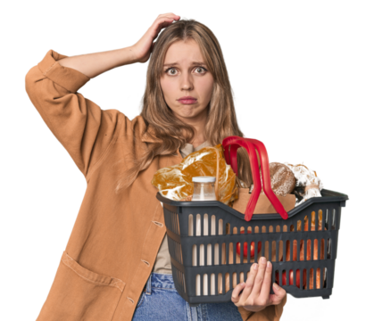 Blonde woman with basket of essentials in studio being shocked, she has remembered important meeting.
