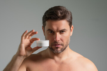 Handsome aged man applying face cream. Beauty routine. Man with perfect skin. Anti-aging and wrinkle cream. Concept of male beauty. Close up face of man applying cream to skin. Skincare and cosmetics.