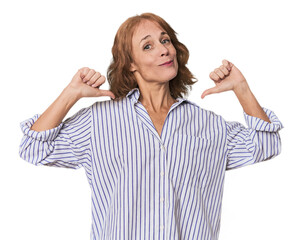 Obraz premium Redhead mid-aged Caucasian woman in studio feels proud and self confident, example to follow.