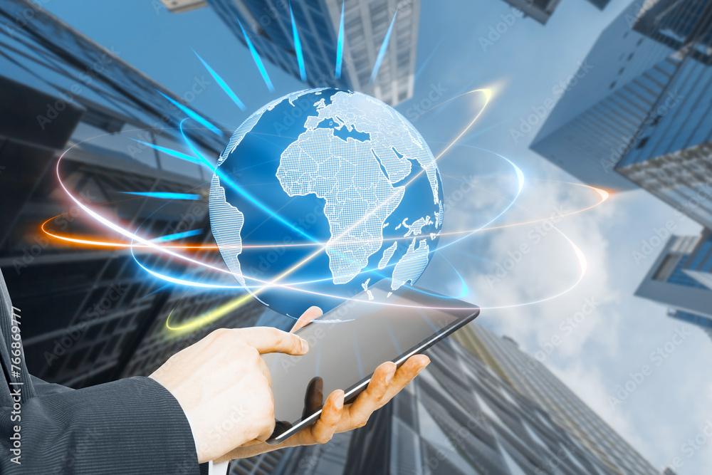 Poster close up of man hand using tablet with glowing futuristic blue globe hologram on blurry city backgro