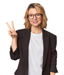 Caucasian woman in black business suit showing victory sign and smiling broadly.