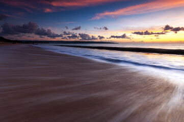 Fototapeta na wymiar Sunset and waves at Jimbaran beach in Bali
