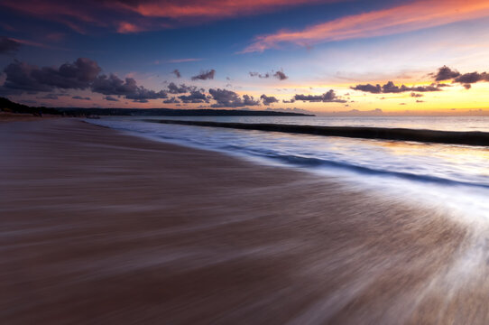 Sunset and waves at Jimbaran beach in Bali