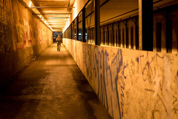 Man Walking In A Neon Lit Tunnel
