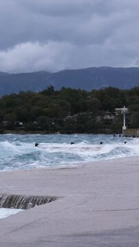Powerful waves crashing the coast in the harbour of Njivice, Croatia after Storm Ciar&aacute;n smashed into Krk Island. Disquiet sea surface, huge water splashes, boats and yachts rocking in the background.