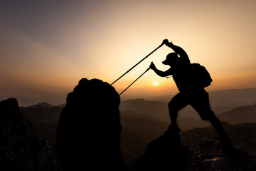 Active climbers enjoy the scenery. Male and female backpackers with backpacks and crutches on top of a mountain.