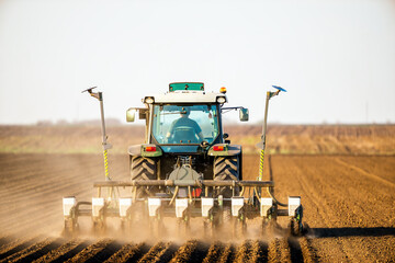 Farmer operating a tractor for sowing crops on fertile farmland, showcasing modern agriculture