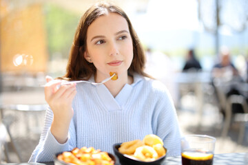 Woman eating tapas in a restaurant terrace - 766884954