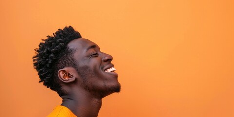 Joyful African Man Laughing on Orange Background - obrazy, fototapety, plakaty