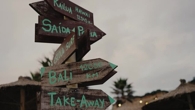 Wooden signpost with arrow pointer with information of direction outdoors. Street guidepost on crossroad 