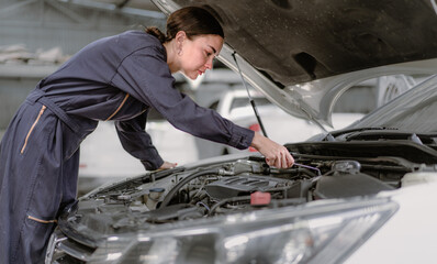Auto mechanic working in vehicle repair service garage. Long hair woman inspecting breaking...