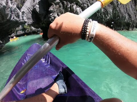 Person paddling purple kayak on the ocean for outdoor recreation Palawan Puerto Princesa Philippines