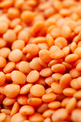 Uncooked red lentils background. Dry orange lentil grains. Close-up