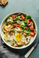 Healthy lunch bowl with salad and fried eggs with mushrooms on table, top view