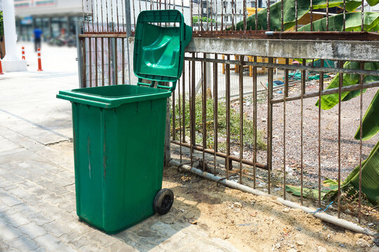 Green public trash can on the road