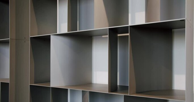 Closeup on wooden empty bookshelf near wall in living room at apartment. Modern furniture, bookcase for organize space
