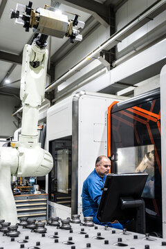 Engineer operating robotic machinery in modern factory