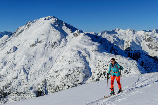 Mature woman back country skiing on Gruenstein with Lechtal Alps in background, Mieming Range, Tyrol, Austria