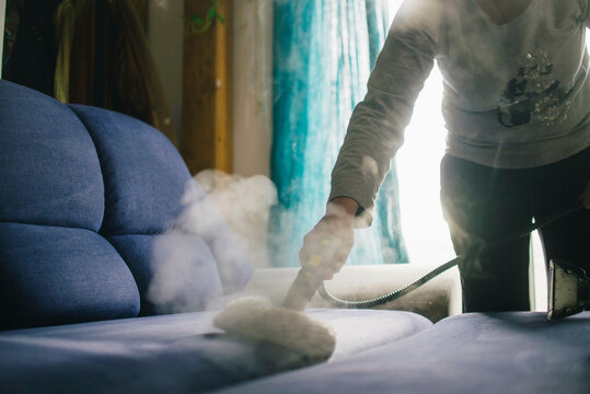 Cleaner steam cleaning sofa with vacuum cleaner at home - Powered by Adobe