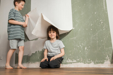 Brothers playing with wallpaper renovating home