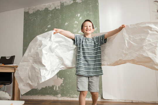 Playful boy with angel wings from old wallpaper at home