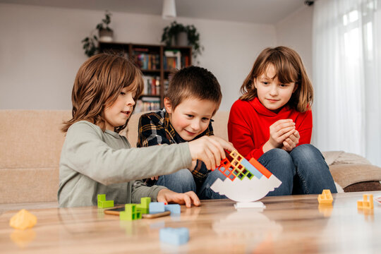 Siblings stacking blocks and playing at home