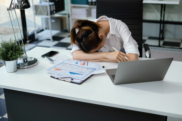 Asian businesswoman works at home office until her body is tired, she is drowsy during the daytime....