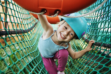 Happy girl having fun playing at rope park