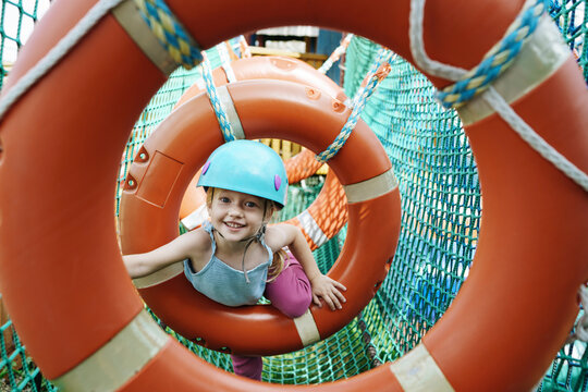 Smiling girl doing obstacle course at rope park