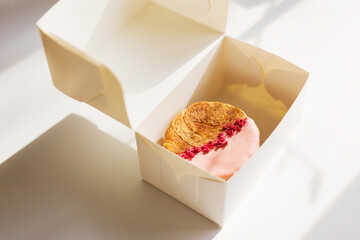 Circular croissants with pink chocolate and freeze-dried raspberries white take away box