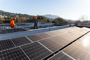 Engineers installing solar panels on rooftop