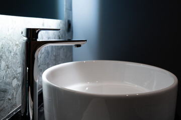 A sleek modern bathroom sink paired with an elegant high faucet set against a luxurious marble wall...