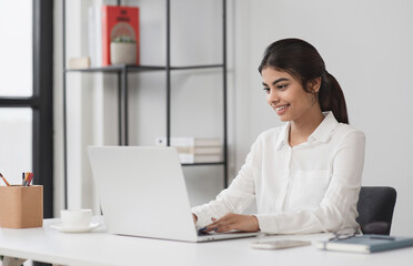 Young woman student using laptop computer at home studying online. Businesswoman working in office. Distance study, work from home, e-learning, business, meeting online