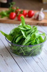 wild garlic, glass bowl, background of herbs and cooking ingredients