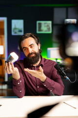 Tech specialist teaching audience how to fix defective smart light bulb on online channel. Technician hosting technology show, doing tutorial on how to mend broken IoT home automation product