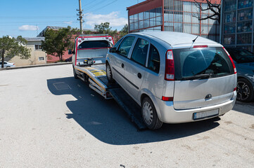 The defective car is unloaded from the tow truck.